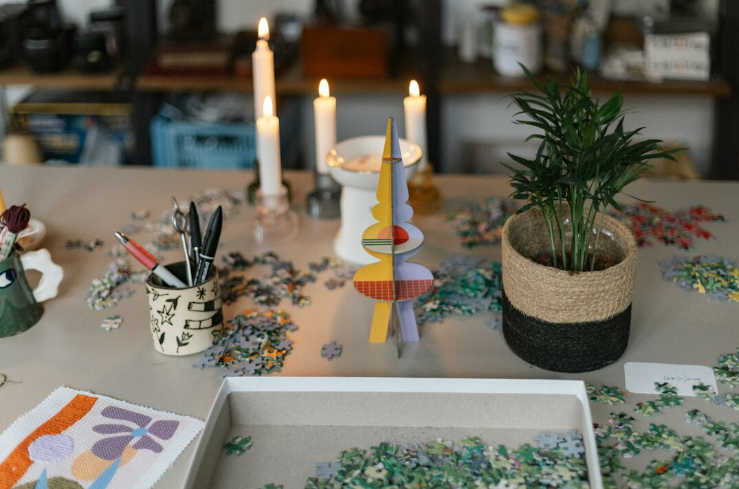 Watercolor paints, brushes and pottery on a wooden workshop table