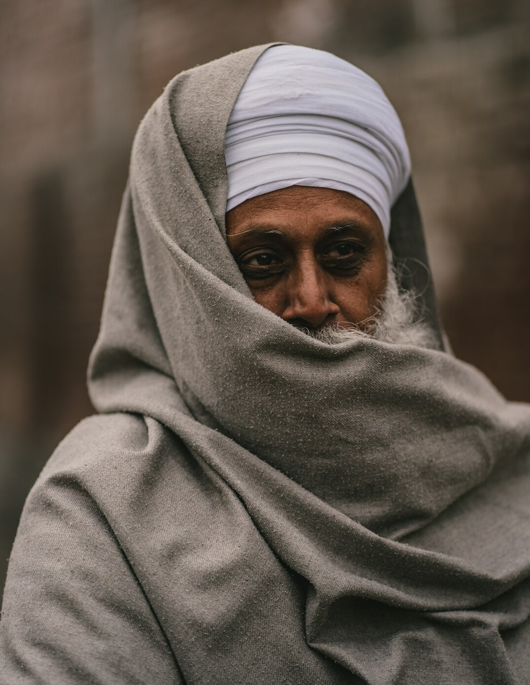 Elderly man with white beard and a scarf outdoors
